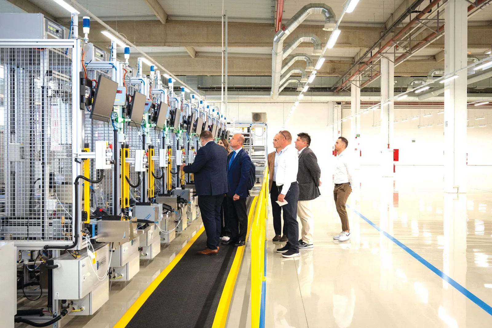 O echipă de specialiști inspectează linia de producție a electrocasnicelor.