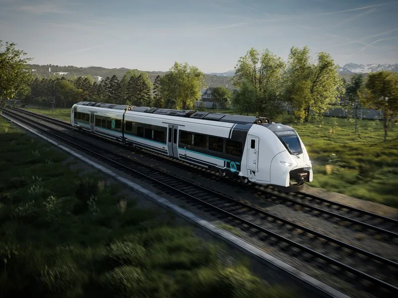 Tren regional pe hidrogen circulând printr-un peisaj verde și natural.