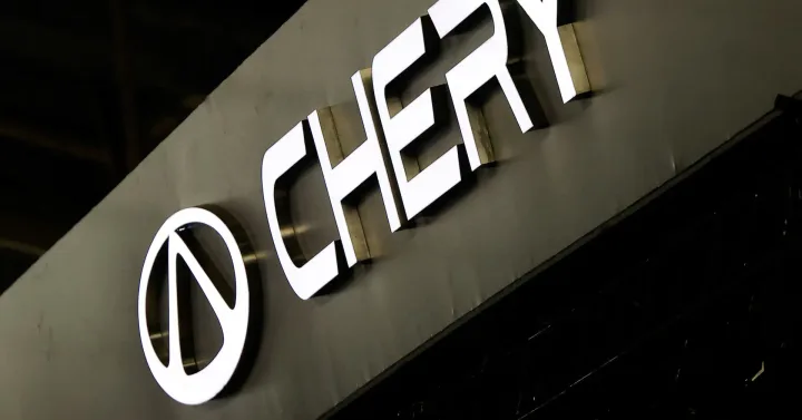 Logo Chery expus la un eveniment auto, simbolizând inovația tehnologică.