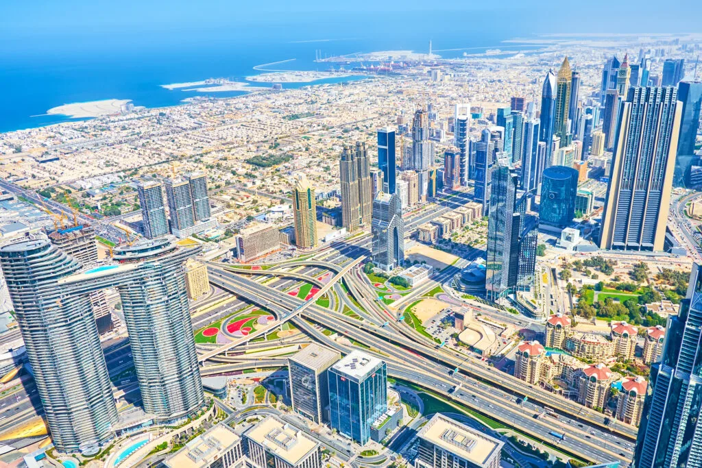 Peisaj urban din Dubai, cu clădiri moderne și drumuri aglomerate.