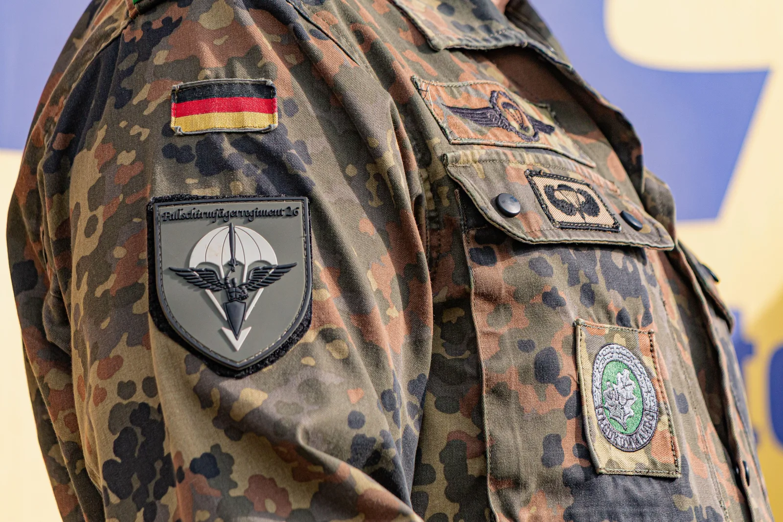 Uniformă militară germană cu insigne distinctive și detalii camuflate.
