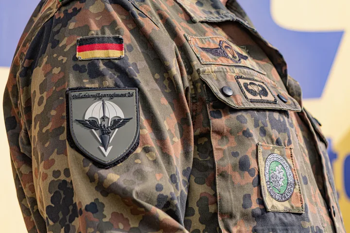 Uniformă militară germană cu insigne distinctive și detalii camuflate.