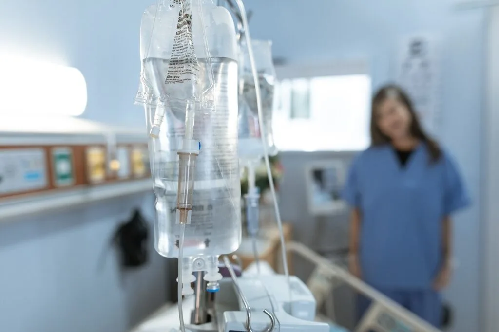 Un pacient în spital, cu perfuzie, evidențiind serviciile medicale private.