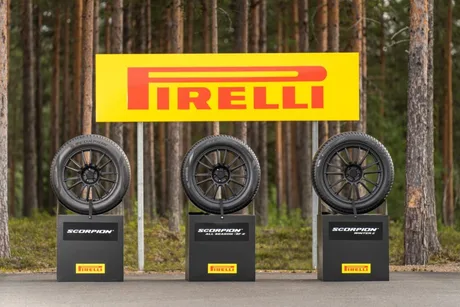 Anvelope Pirelli expuse în fața unui panou publicitar, într-un cadru natural.