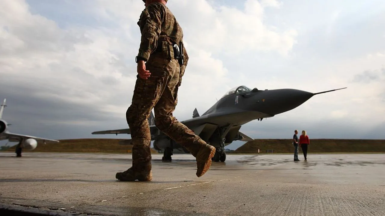 Soldat lângă un avion MiG-29 pe un aeroport polonez.