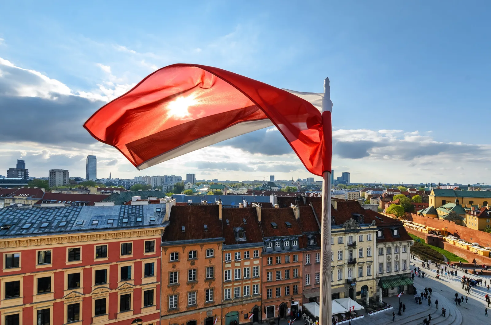 Steagul Poloniei fluturând deasupra clădirilor istorice din Varșovia.