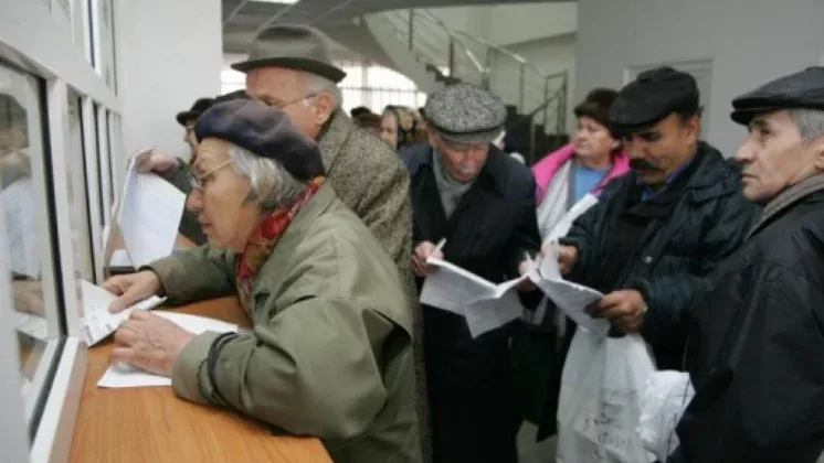 Pensionari așteptând la ghișeu pentru informații despre pensii.