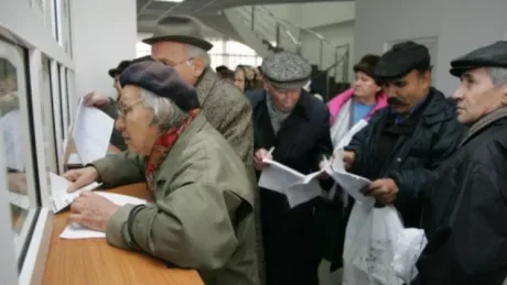 Pensionari așteptând la ghișeu pentru informații despre pensii.
