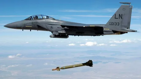 Avion militar lansând o bombă inteligentă în timpul unei misiuni aeriene.