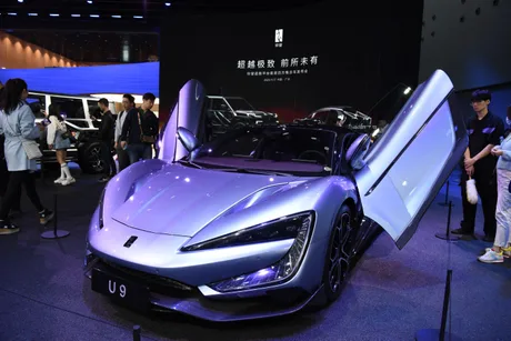 Mașină sportivă electrică cu uși deschise, expusă la un eveniment auto.