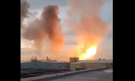 Explozie puternică în apropierea unei baze militare, cu fum și flăcări vizibile.