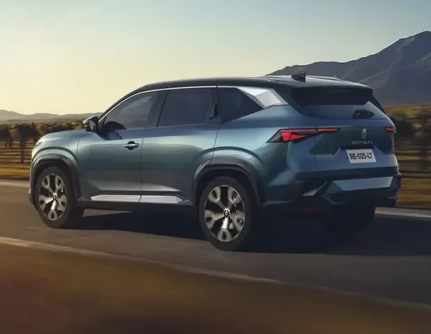 Un SUV modern parcurs pe un drum rural, înconjurat de peisaje naturale.