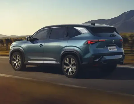 Un SUV modern parcurs pe un drum rural, înconjurat de peisaje naturale.