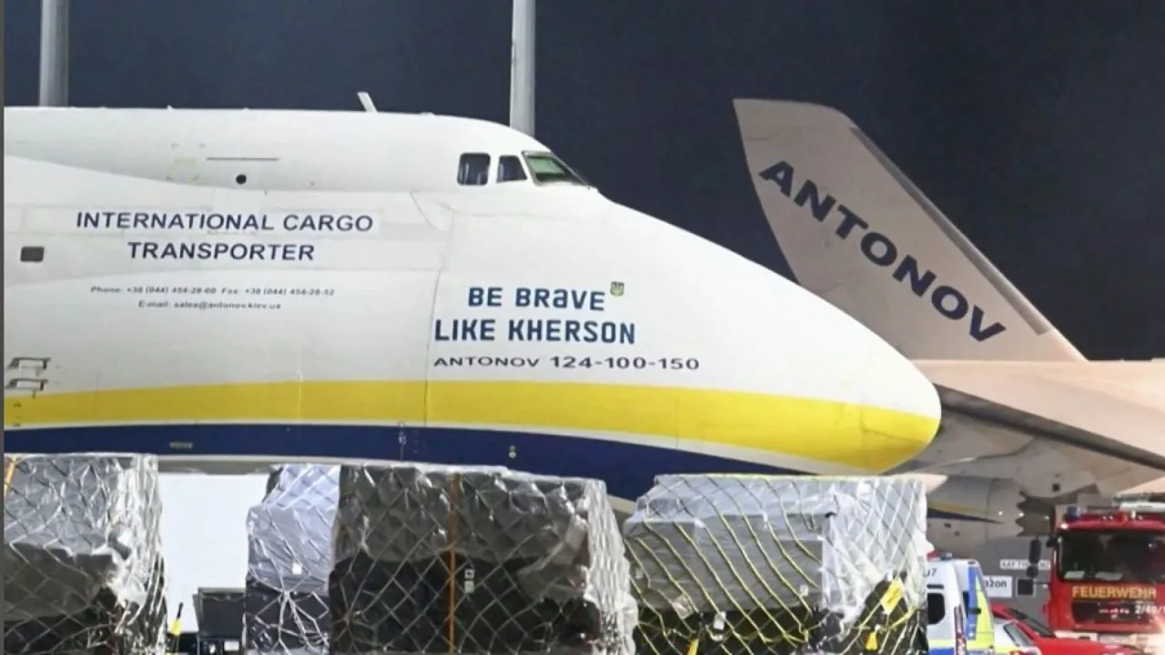 Avion cargo pe pista aeroportului, cu mărfuri securizate în jur.