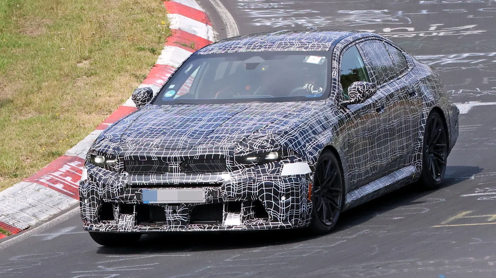Prototip BMW M5 camuflat testat pe circuitul Nürburgring, cu design modernizat.