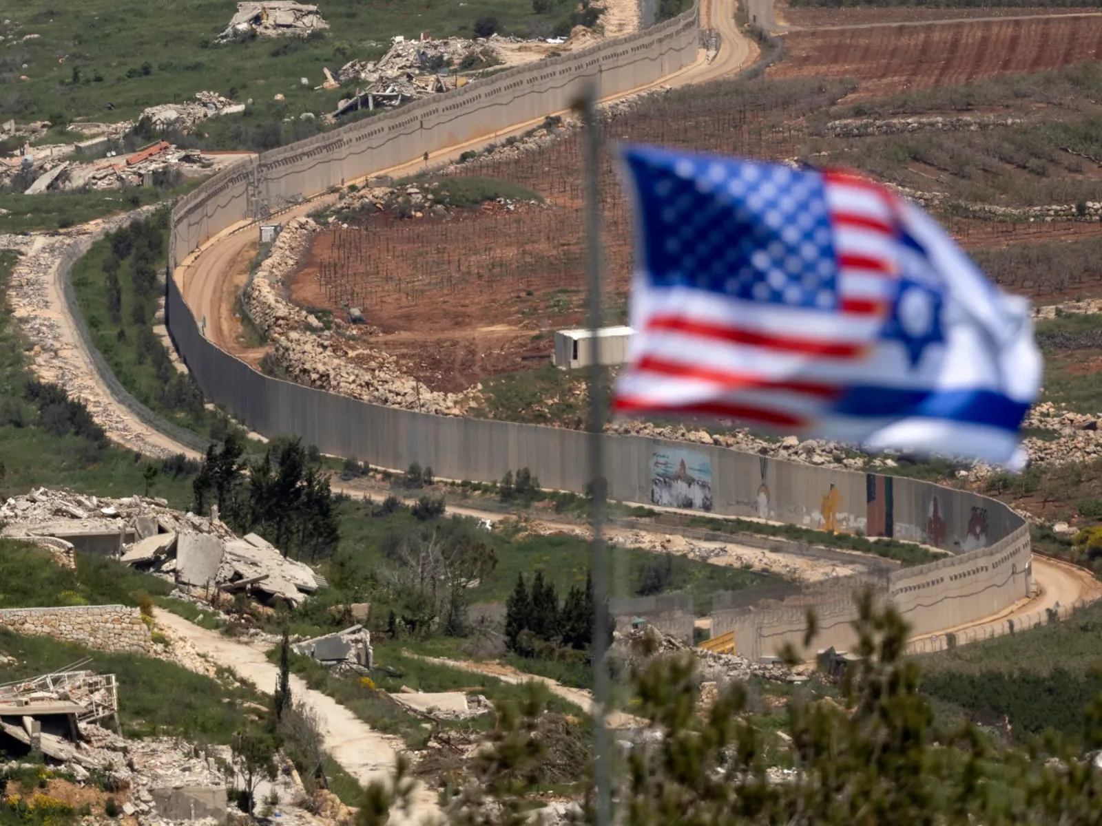 Steagurile SUA și Israelului fluturând lângă o zonă de conflict.