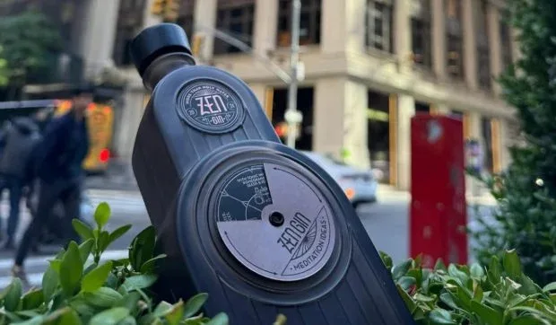 Sticlă de gin Zen, cu design inspirat din arhitectura New York-ului, pe fundal urban.