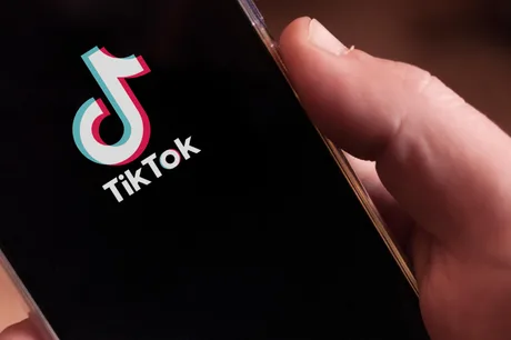 Logo-ul TikTok pe un telefon mobil, simbolizând inovația în plăți digitale.