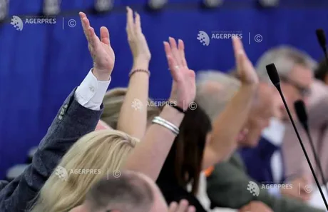 Mâini ridicate în semn de vot în Parlamentul European.