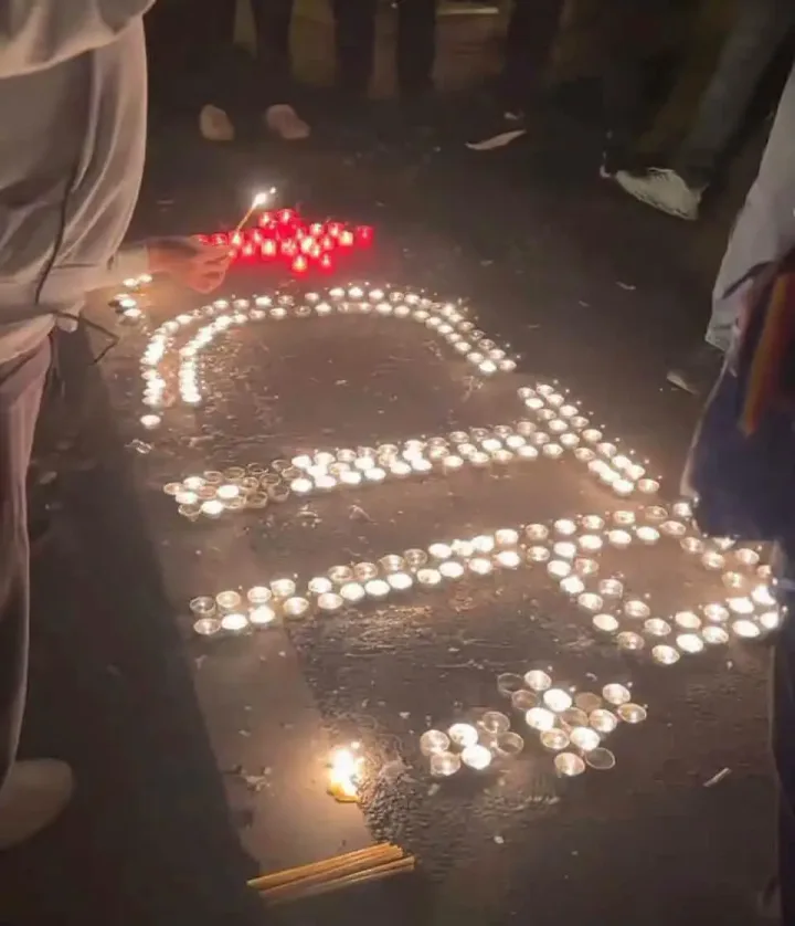 Protestatarii aprind lumânări formând inițialele unui jurnalist în fața Arestului Central.