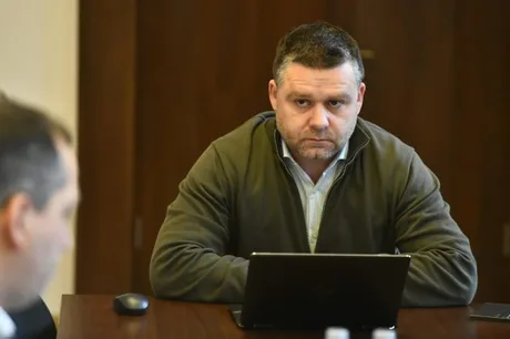Ciprian Ciucu în timpul unei ședințe, cu un laptop în față.