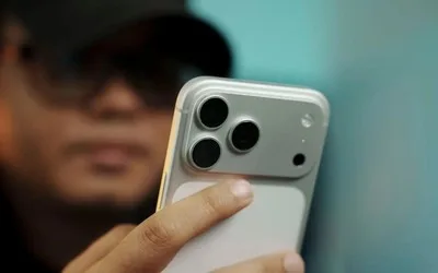 Utilizator examinând un smartphone cu cameră avansată.