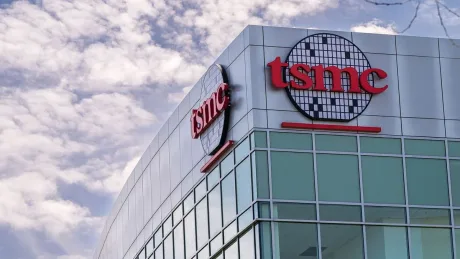 Clădire TSMC cu logo pe fond de cer senin.