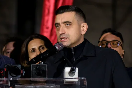 Adrian Veștea vorbește la microfon, înconjurat de susținători.