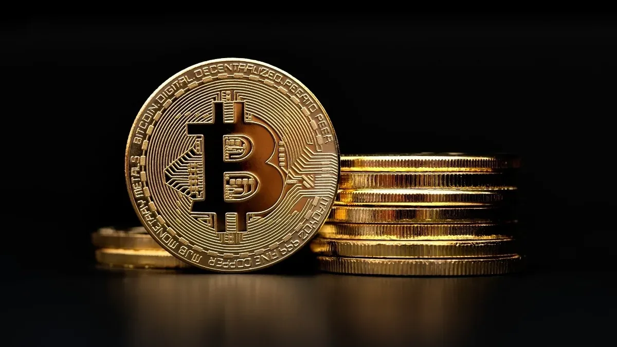 Monede Bitcoin așezate pe un fundal întunecat, simbolizând volatilitatea pieței.