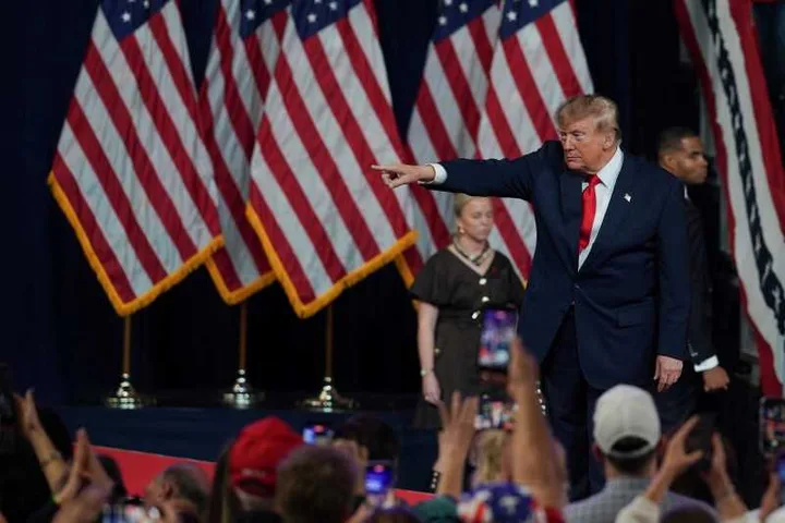 Donald Trump la un miting electoral, sub steaguri americane.