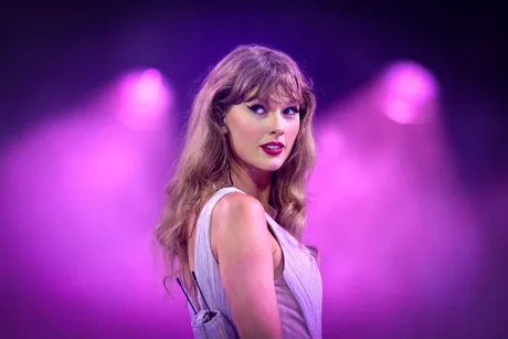 Taylor Swift pe scenă, în lumina reflectoarelor violet.