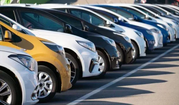 O linie de automobile parcate, variate în culori și modele.