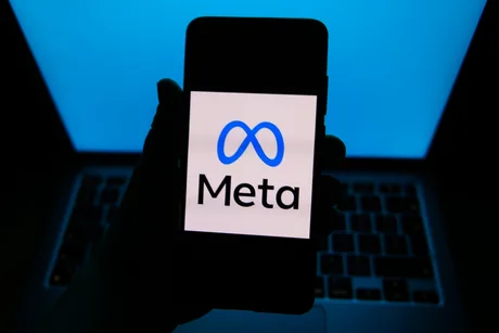 Logo-ul Meta pe un telefon mobil, cu un fundal albastru.
