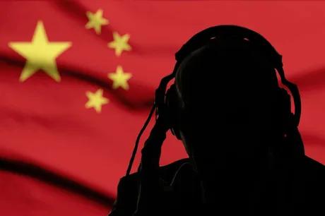 Silhouette a unei persoane cu căști, pe fundalul steagului Chinei.
