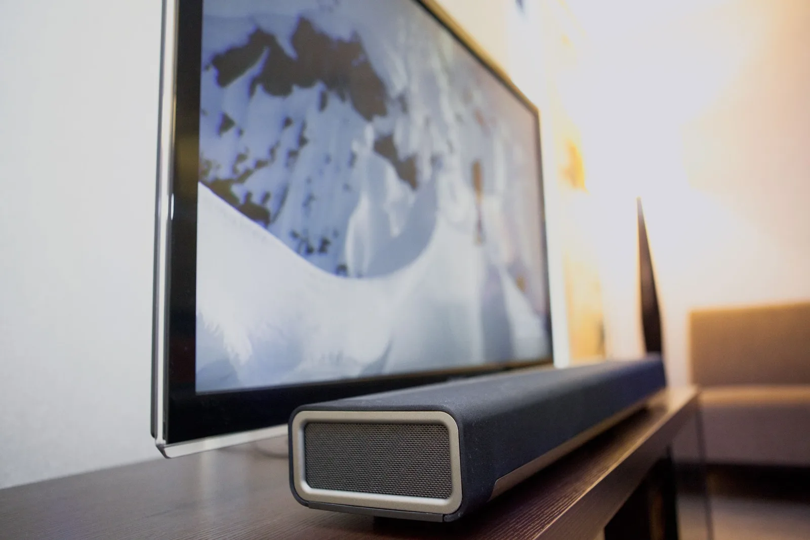 Bara de sunet Sonos pe un suport lângă televizor, pregătită pentru utilizare.