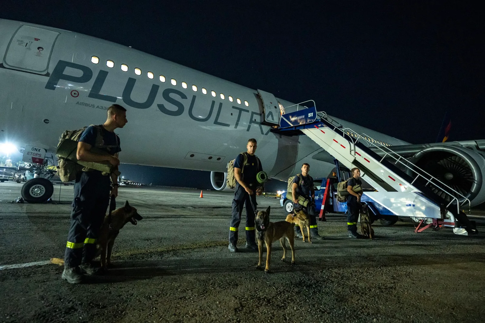 Echipe de salvare pregătite pentru intervenție în Venezuela, lângă un avion de transport.