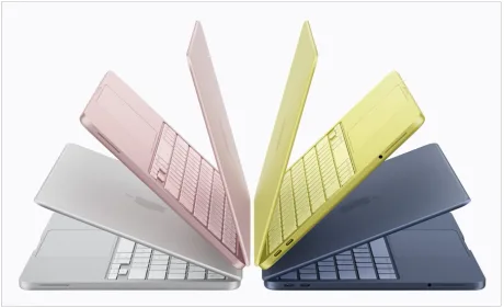 Laptopuri Mac în culori variate, aranjate artistic, evidențiind designul modern.