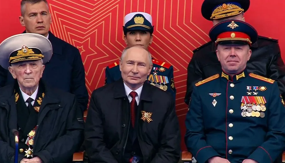 Vladimir Putin la parada de 9 mai, înconjurat de oficiali militari.
