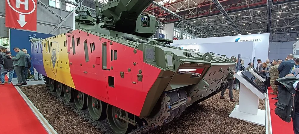Vehicul militar cu steagul României expus la un târg de apărare.
