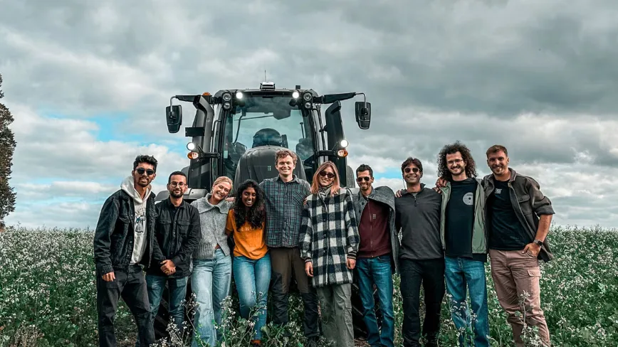 Echipa PerPlant în fața unui tractor pe câmp, promovând tehnologia agricolă avansată.