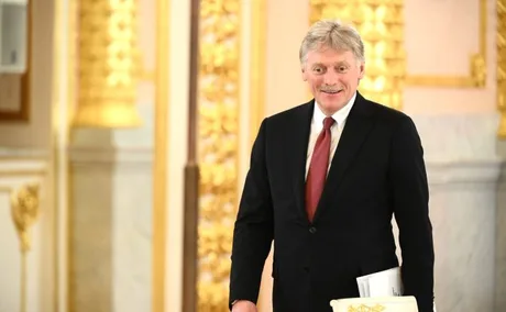 Reprezentant al Rusiei într-o sală elegantă, zâmbind.