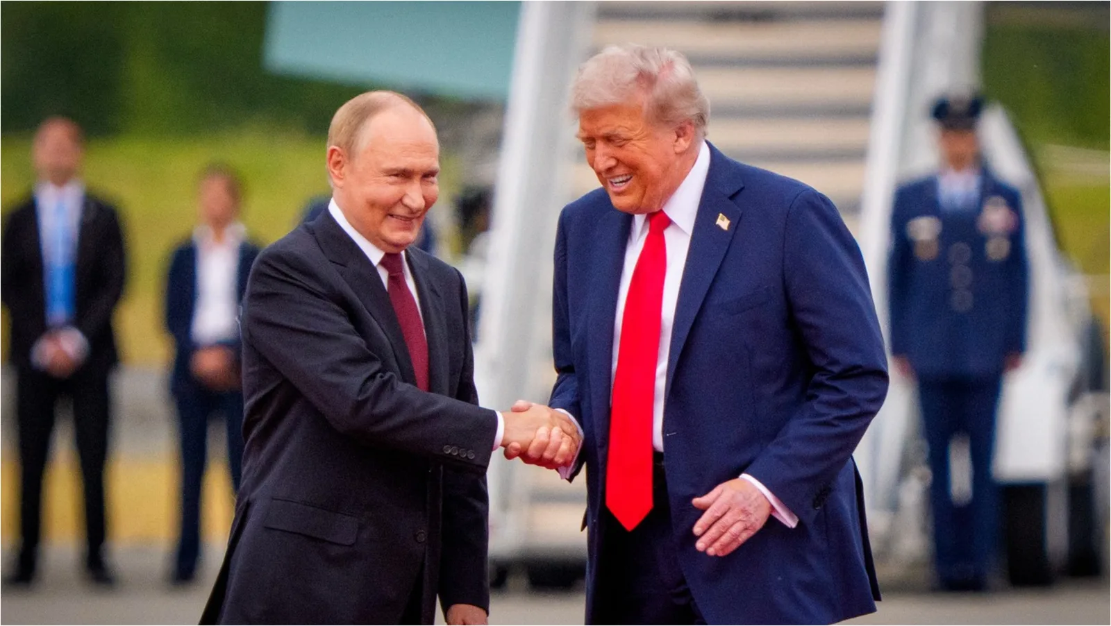 Donald Trump și Vladimir Putin se salută la o întâlnire oficială.