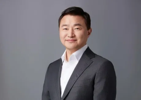 Roh Tae-moon, șeful diviziei DX de la Samsung, zâmbește în costum.