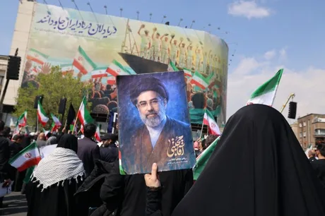 Proteste în Iran după asasinarea lui Ali Larijani, cu oameni purtând pancarte.
