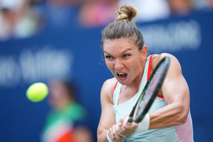 Simona Halep în acțiune pe terenul de tenis, concentrată.
