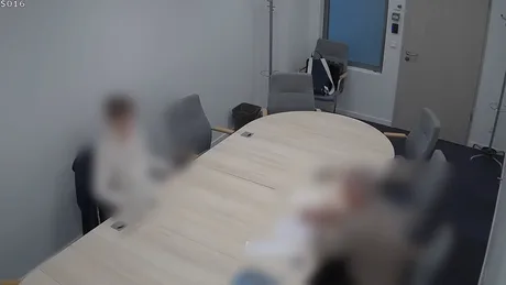 Discuție într-o cameră de interogare despre acuzații de spionaj cibernetic.