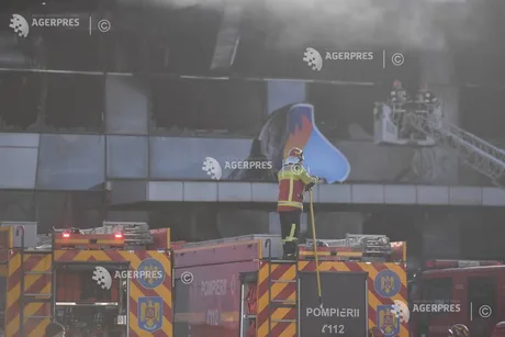 Pompieri intervenind la un incendiu într-un depozit industrial.