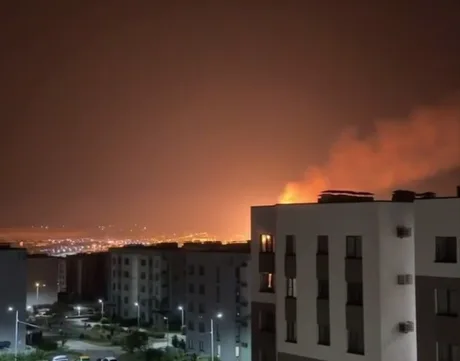 Flăcări și fum se ridică deasupra orașului în timpul atacurilor nocturne.