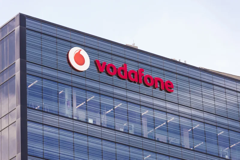 Clădire Vodafone cu logo pe fațadă, simbol al telecomunicațiilor.