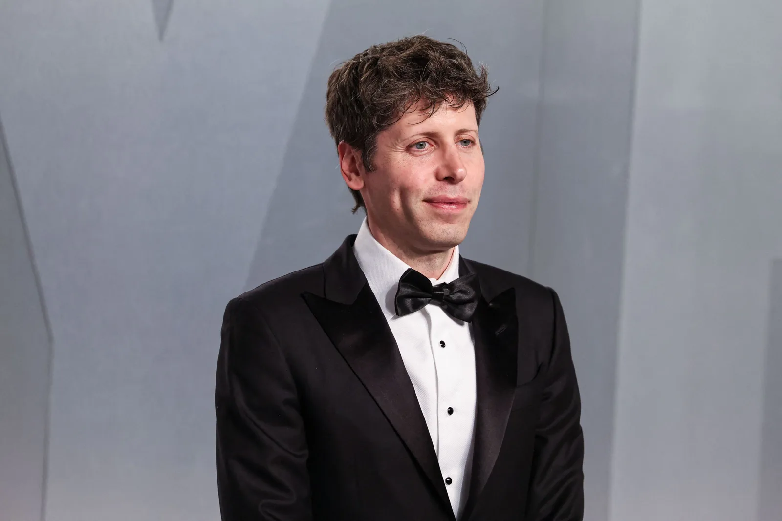 Sam Altman la un eveniment, îmbrăcat elegant, discutând despre viitorul OpenAI.
